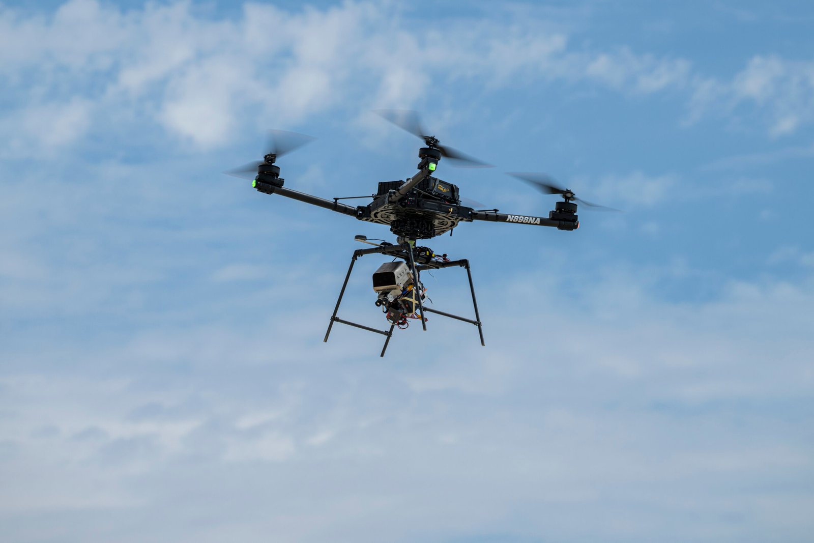 A remotely piloted drone with four rotors carries a guidance and navigation experiment through flight maneuvers.